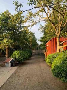 a dirt road with a red fence and a smallshed at Vacations for a good cause in Drochtersen