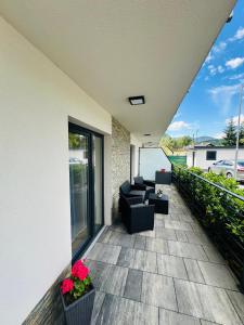 a patio with couches and flowers on a building at J&M apartman in Liptovská Teplá