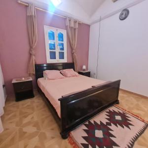 a bedroom with a bed and a tv in it at Maison d'été hessi Jerbi ras marmour in Zarzis