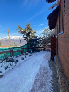 a driveway covered in snow next to a house at Tiny Under Chalet in Santiago