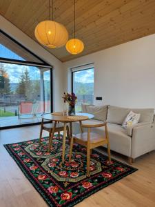 a living room with a table and a couch at Boiko house - котеджі з чаном-джакузі та басейном in Slavske