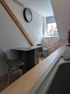 an attic room with a desk and a clock on the wall at L'industriel in Sarreguemines +5 photos