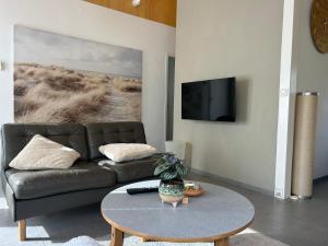 a living room with a couch and a table at Palm89 in Warmenhuizen