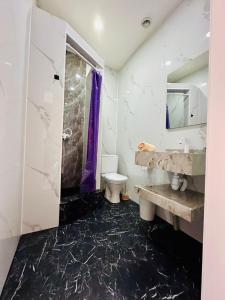 a bathroom with a sink and a toilet and a mirror at Гостиница Желкен in Aktobe