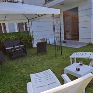 a patio with a white umbrella and a table and chairs at Ljubičica deluxe 2 - Novo - Privatno dvorište - Parking in Vrnjačka Banja