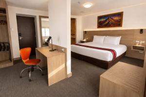 a hotel room with a bed and a desk with a chair at Ecoterra Essentials San Blas in Cusco