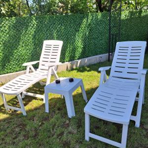 two white chairs and a table and a chair at Ljubičica deluxe 2 - Novo - Privatno dvorište - Parking in Vrnjačka Banja