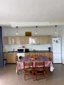 a kitchen with a table with chairs and a refrigerator at Kibula Horizon in Ureki