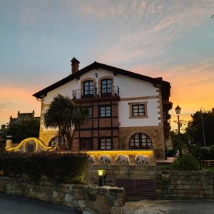 a house with a sunset in the background at Posada la Leyenda in Santillana del Mar