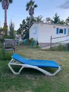 a blue bench sitting in the grass in front of a house at Little house paradise in Sant Pau dʼOrdal