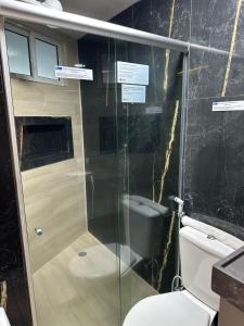 a bathroom with a glass shower with a toilet at Blue Sunset Flats Beira Mar - Apt 322 in João Pessoa