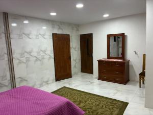 a bedroom with a mirror and a dresser with a purple bed at Garsol in Oruro