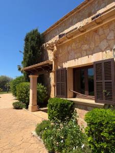 a stone building with a window and some bushes at Finca Sara Christiana in Campos