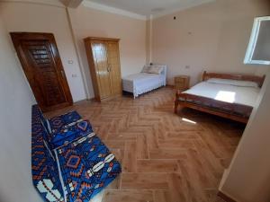 a bedroom with two beds and a wooden floor at Spacious Villa-walking to beach in Marsa Matruh +29 photos
