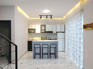 a kitchen with white cabinets and a kitchen island at redHome in Gabala