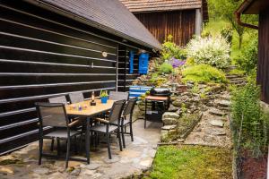 a patio with a table and chairs in a garden at Valašská chalupa Červenka in Lužná