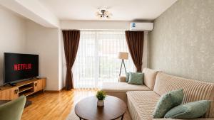 a living room with a couch and a tv at Central Apartments Kukoski Near Lake & Old Town in Ohrid