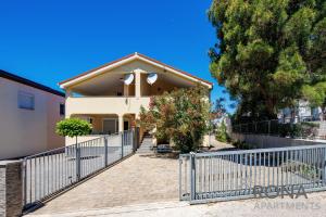 a house with a fence in front of it at Rona Apartments Zlatko in Šimuni