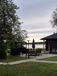 a picnic table and an umbrella in a park at Cottage in Raahe in Raahe +4 photos