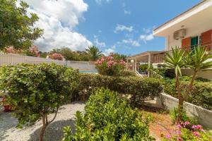 a garden with trees and bushes in front of a house at Elia serenity apartment 4 in Mesochórion