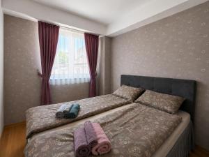 a bedroom with a bed with two towels on it at Central Apartments Kukoski Near Lake & Old Town in Ohrid