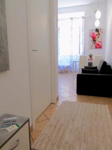 a living room with a white door and a black couch at DOS Gardenias B&B in Pozzuoli