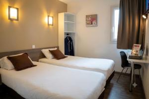 a hotel room with two beds and a desk at Fasthôtel Périgueux - Un Hôtel FH Confort in Marsac-sur-lʼIsle