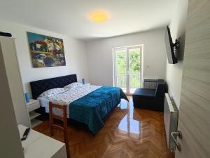 a small bedroom with a bed and a window at Apartments Valter Frankovic in Mošćenička Draga