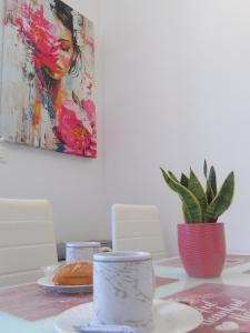 a dining room table with a painting of a woman at DOS Gardenias B&B in Pozzuoli