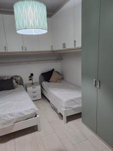 a bedroom with two beds and a chandelier at Le due Rive in Tufo