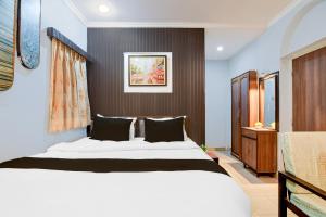 a bedroom with a large white bed with black pillows at Collection O Lake Mall Kalighat Formerly Venkateshwara in Kolkata