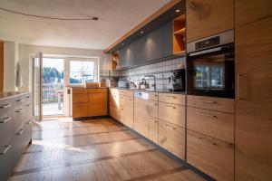 a large kitchen with wooden cabinets and wooden floors at Alpe Sonnenruh in Buchenberg +36 photos