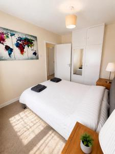 a bedroom with a large white bed and a couch at Spacious 2 bedroom apartment near Wembley stadium with free parking in London