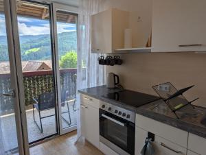 a kitchen with a stove top oven next to a balcony at Zirbitzblick in Mönchegg