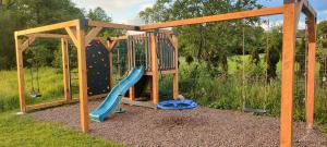 a playground with a slide and a climbing frame at Apartamenty Boczna 3B z sauną i balią in Kudowa-Zdrój