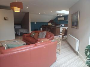 a living room with a red couch and a kitchen at Ethan House Holiday Suites in Killarney +19 photos