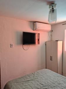 a bedroom with a tv on the wall and a bed at Lo de Xime in Yerba Buena