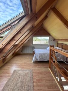 a attic bedroom with a bed and windows at La Petite Maison Bénance in Sarzeau