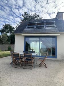 a table and four chairs in front of a house at La Petite Maison Bénance in Sarzeau