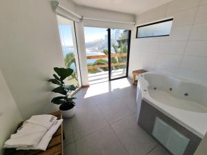 ein Badezimmer mit Badewanne und Topfpflanze in der Unterkunft Maré Hotel Boutique in Viña del Mar + 50 Fotos