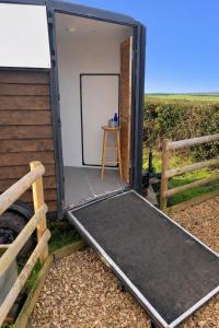 a small trailer with a door open and a table at Wiltshire Weavers Hut in Chippenham