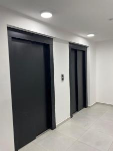 two black sliding doors in a room with a tile floor at Monoambiente Cipolletti in Cipolletti +2 photos