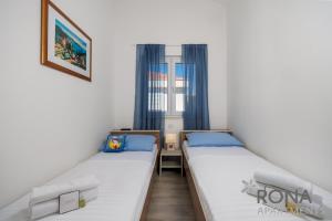 two beds in a small room with a window at Rona Apartments Zlatko in Šimuni