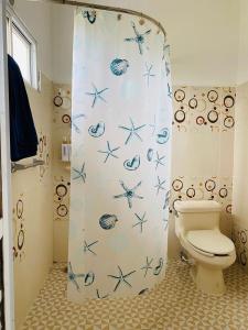 a bathroom with a shower curtain with a toilet at Paraiso Suite Centrico con entrada independiente in Paraíso +11 photos