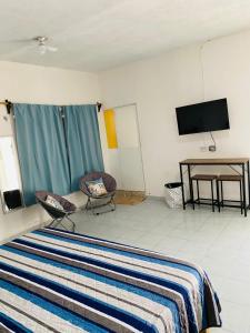 a hotel room with a bed and a television at Paraiso Suite Centrico con entrada independiente in Paraíso