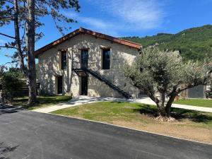 a stone house with a tree in front of it at Appartement PICHOLINE in Saint-Sorlin-en-Bugey