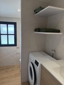 a laundry room with a washing machine and a window at Appartement PICHOLINE in Saint-Sorlin-en-Bugey