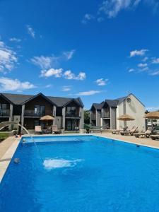 a large blue swimming pool with houses in the background at Apartamenty Marinera in Łeba