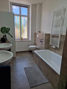 a bathroom with a tub and a toilet and a sink at Echternach Center Charming Apartment in Echternach