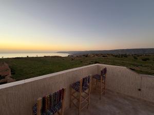 two chairs on a balcony with a view of the ocean at Gaia guest house in Taghazout